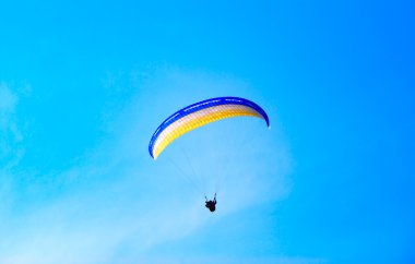 Parachute against the pure blue sky clipart