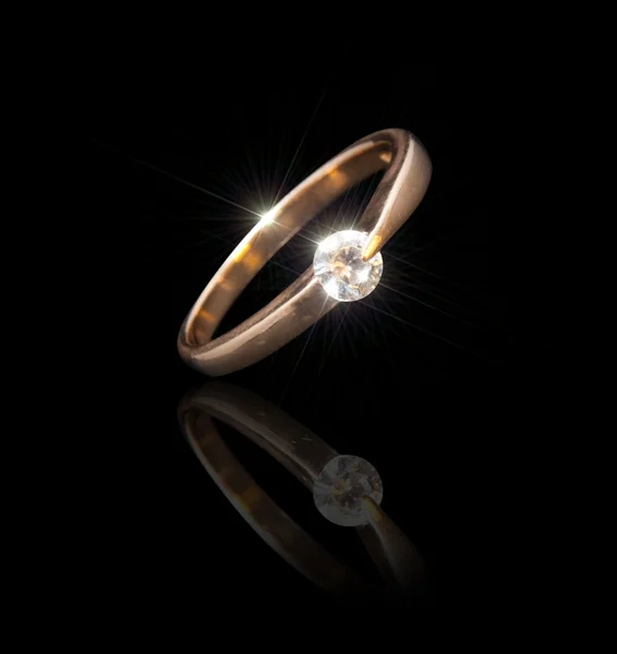 Anel de ouro com um brilhante em um fundo preto — Fotografia de Stock