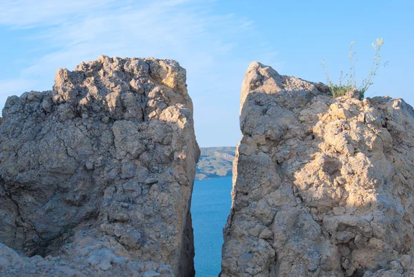 Rachadura em uma rocha através da qual o mar e o céu são visíveis — Fotografia de Stock