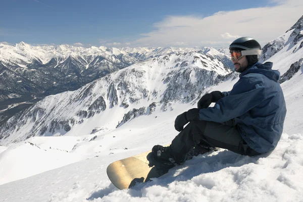Mladý snowboardista sedí — Stock fotografie