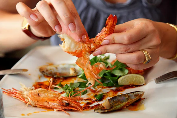 Female hands are scaling shrimp