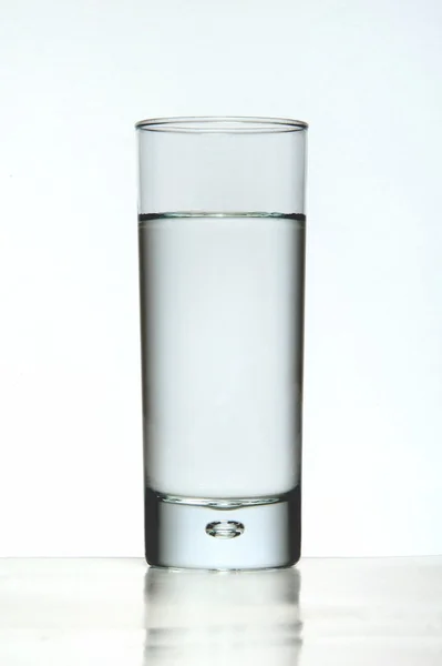 Com um copo de água sobre um fundo branco — Fotografia de Stock