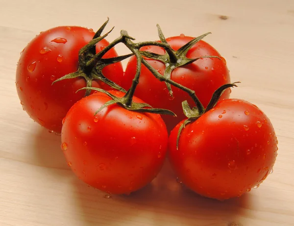 Quattro pomodori sul tavolo — Foto Stock