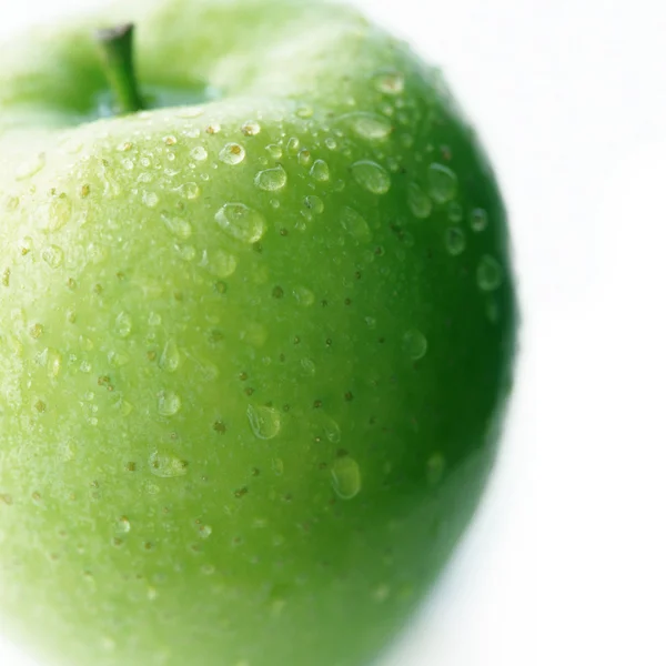 Pomme verte avec des gouttes d'eau sur fond blanc — Photo