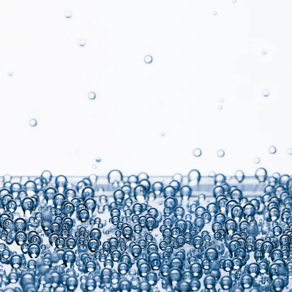 Voda s bublinkami na bílém pozadí — Stock fotografie