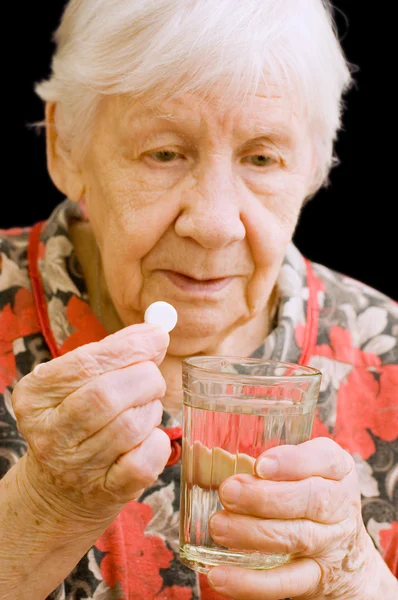 Die alte Frau trinkt eine Tablette — Stockfoto