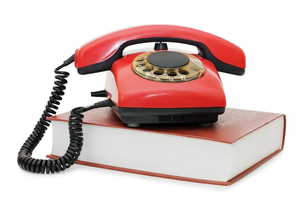 Telefono rosso sul libro isolato — Foto Stock