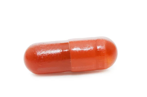 Píldora roja aislada sobre fondo blanco — Foto de Stock