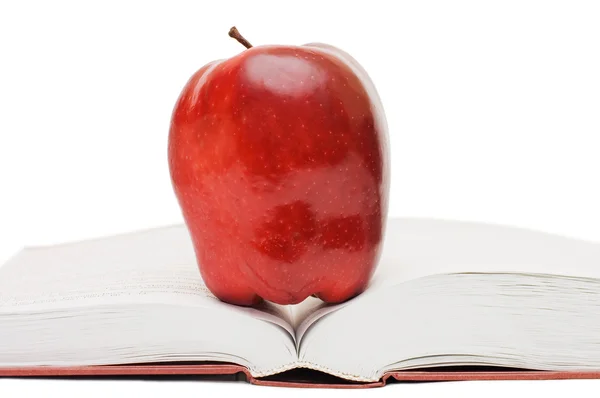 Rode appel op het open boek Stockfoto