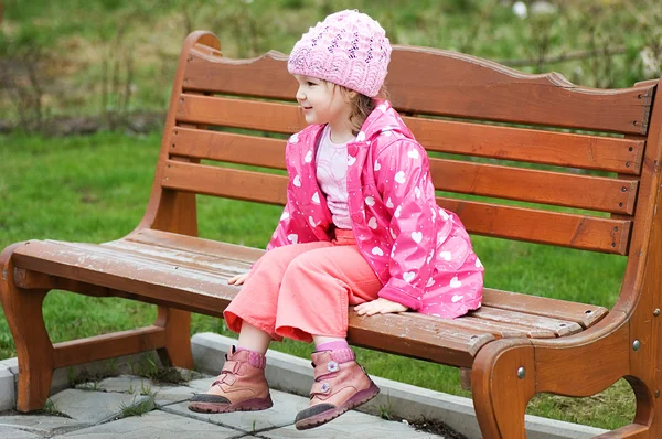 Маленькая девочка в парке на скамейке — стоковое фото