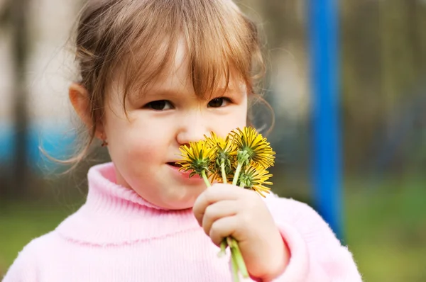 A menina cheira a flores. — Fotografia de Stock
