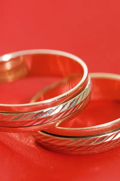 Dois anéis de casamento de ouro no vermelho — Fotografia de Stock
