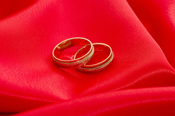 Dois anéis de casamento de ouro no vermelho — Fotografia de Stock