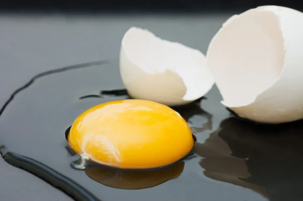 O ovo quebrado isolado em preto — Fotografia de Stock