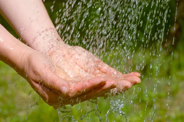Hände fangen sauberes fallendes Wasser — Stockfoto