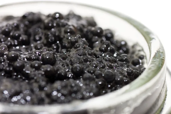 Caviar preto em um jarro de vidro em um branco — Fotografia de Stock