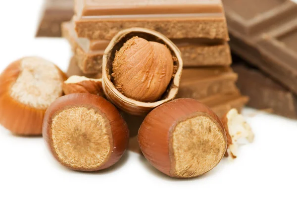 Chocolate and hazelnuts on white background — Stock Photo, Image