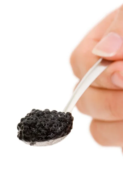 Caviar noir sur une cuillère isolée sur blanc — Photo