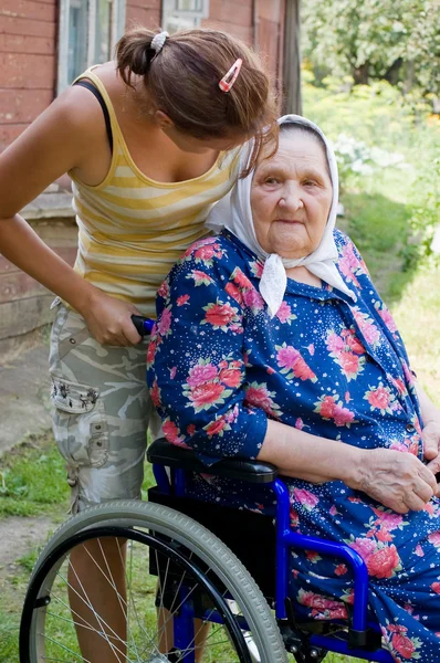 Vieille femme dans un fauteuil invalide — Photo