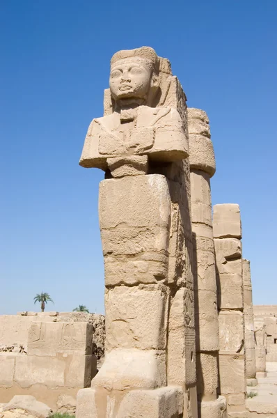 Sochu starověkého faraona a sloupec na pozadí podsvíceným oblohy — Stock fotografie