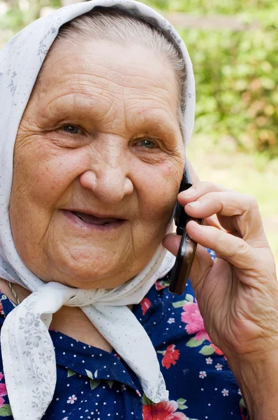 Бабушка разговаривает с телефоном — стоковое фото