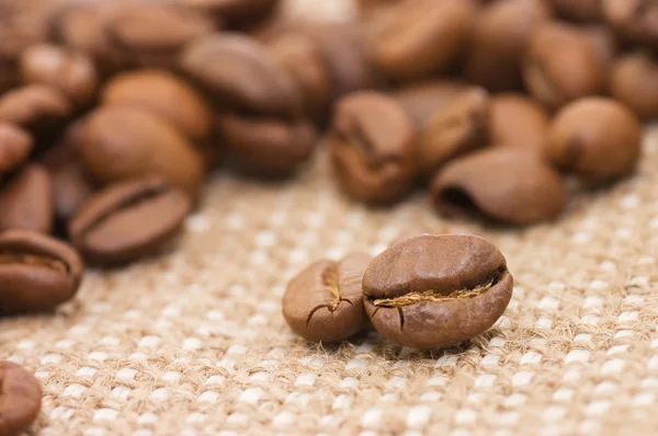 Bruin koffie korrels op een plundering — Stockfoto
