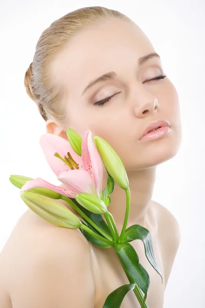 Cara de mujer con una flor rosa . Imágenes de stock libres de derechos