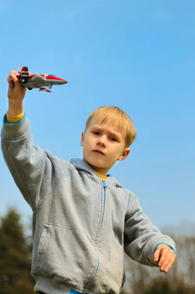 Little boy is playing with toy airplane — Stock Photo, Image
