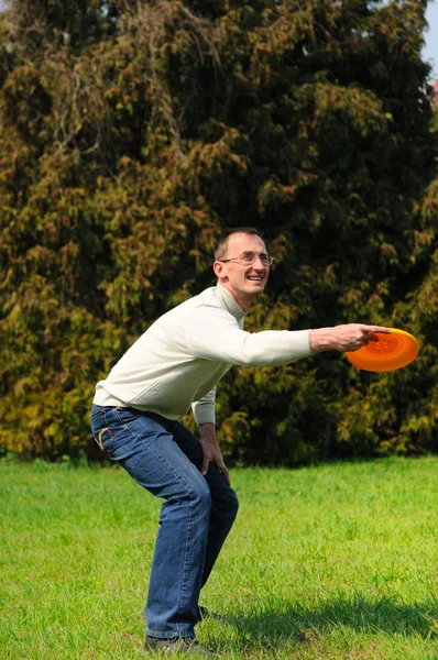 Knappe jonge man speelt frisbee — Stockfoto