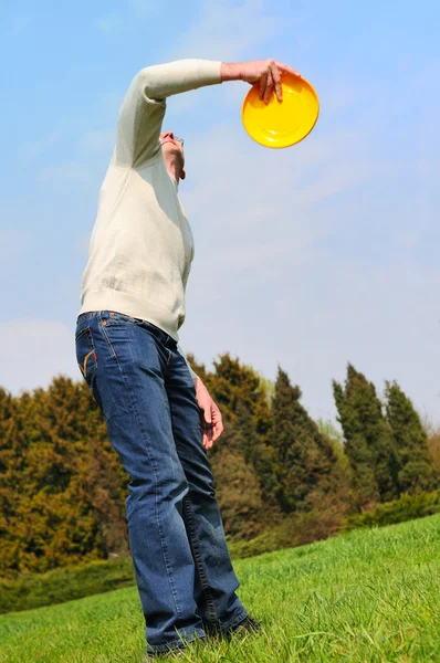 Handsome young man is playing Frisbee — Stock Photo, Image