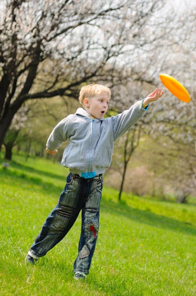 Kleine jongen speelt frisbee — Stockfoto