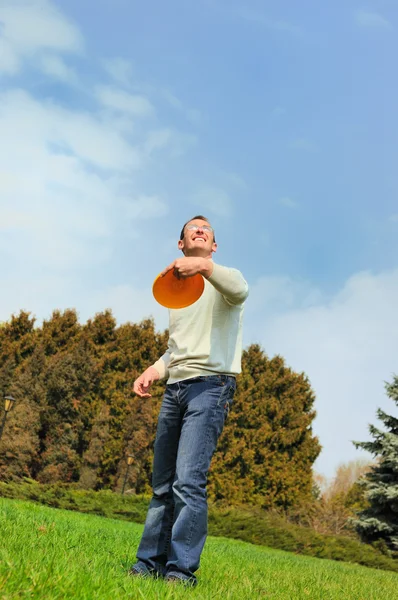 Handsome young man is playing Frisbee — Stock Photo, Image