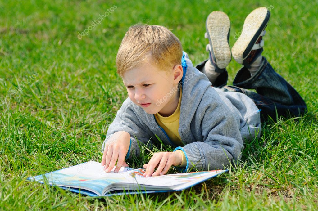 Niño Está Leyendo Un Libro Al Aire Libre Niño Está Leyendo Un Libro Al Aire Libre