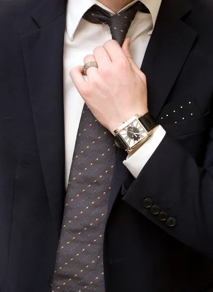 Молодой человек в костюме, завяжите галстук — стоковое фото