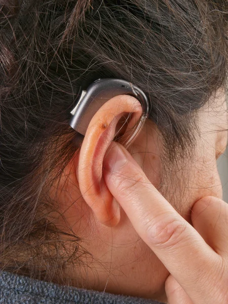 Mulher usando aparelho auditivo — Fotografia de Stock