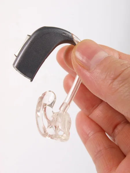 Рука тримає слуховий апарат Ліцензійні Стокові Зображення