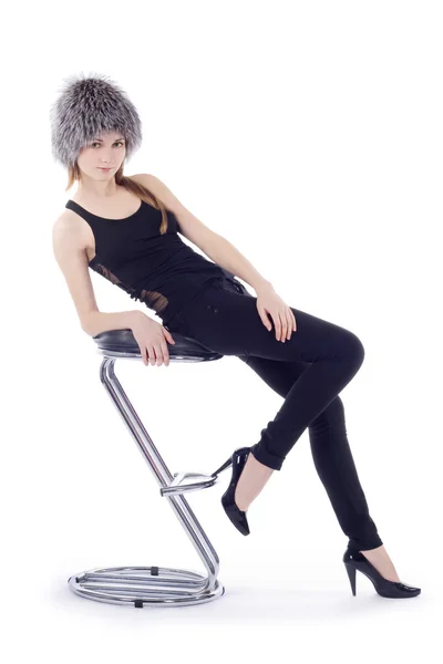 Žena kožešinovou čepicí seděl na židli — Stock fotografie