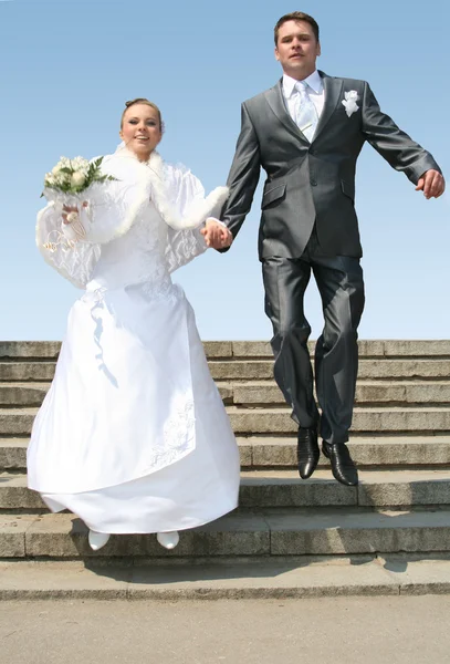 Manžel a nevěsta skákání — Stock fotografie