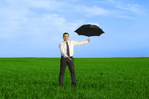 Happy businessman standing with umbrella — Stock Photo, Image