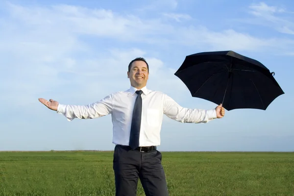 Бизнесмен стоит с зонтиком — стоковое фото