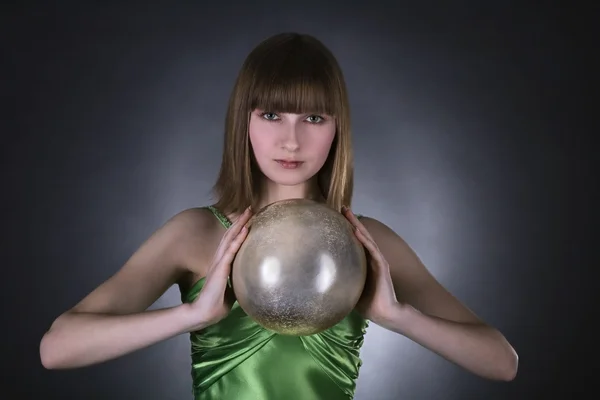 Impresionante mujer en vestido verde con esfera de oro —  Fotos de Stock
