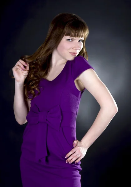Prachtige vrouw in paarse jurk — Stockfoto