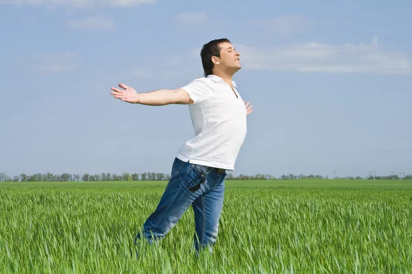 Young man moves in a green field — Stock Photo, Image