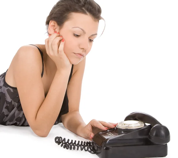 Jeune femme regardant vieux téléphone — Photo