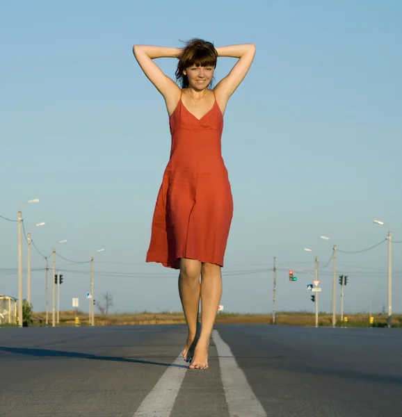 Girl walk barefoot on empty road — Stock Photo, Image