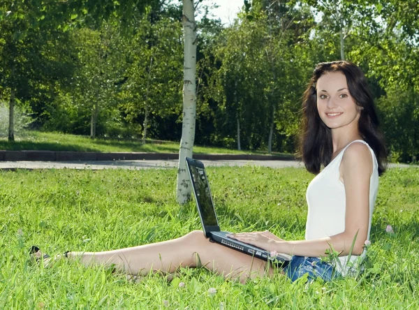 Красива жінка в парку з ноутбуком — стокове фото