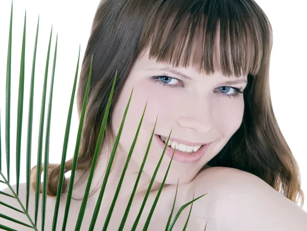 Bonito rostro de mujer escondida detrás de la gran hoja de palma verde — Foto de Stock
