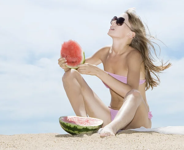 Mulher posando na praia e comendo melancia — Fotografia de Stock