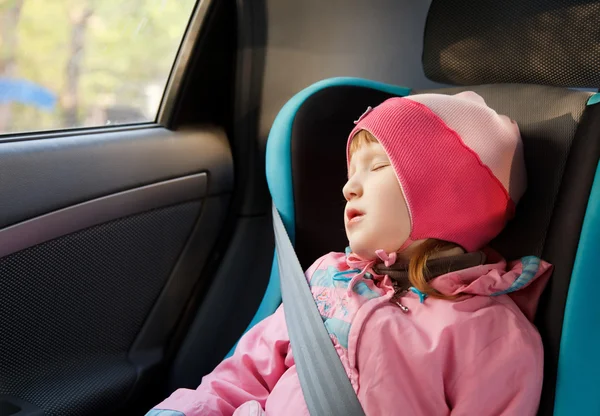 Liten flicka sova i en bil — Stockfoto