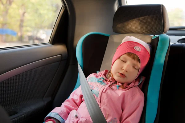 Liten flicka sova i en bil — Stockfoto